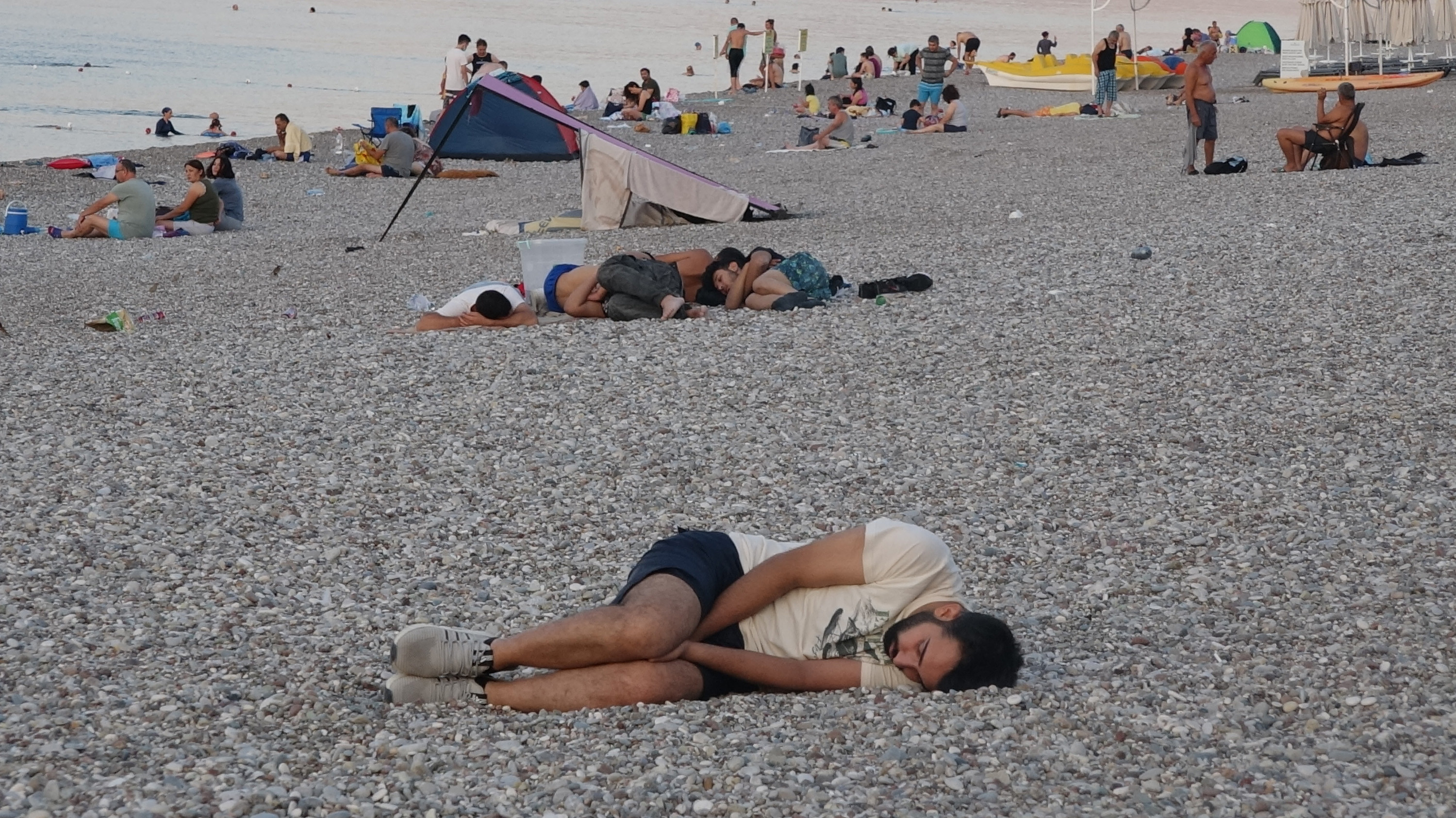 Sıcaktan bunaldılar, sahilde uyudular