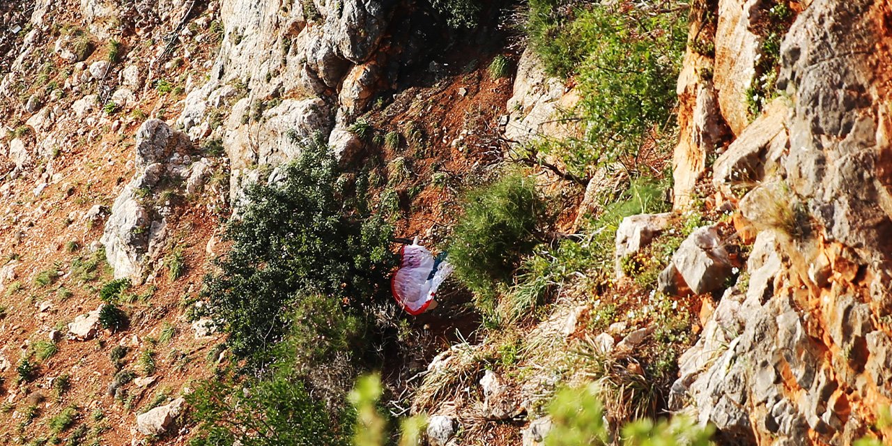 Alanya'da kayalıklara düşen yamaç paraşütü pilotu yaralandı