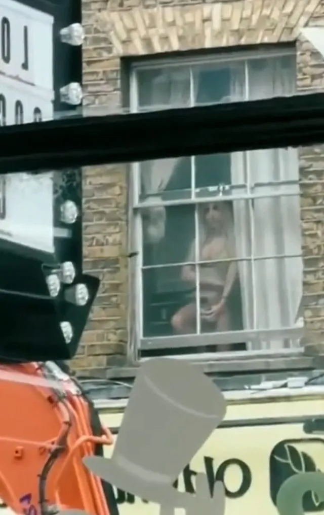 Yarı çıplak camın önüne geçip fotoğraflarını çekti! Karşı binadakilerin kendisini izlediğinden habersizdi