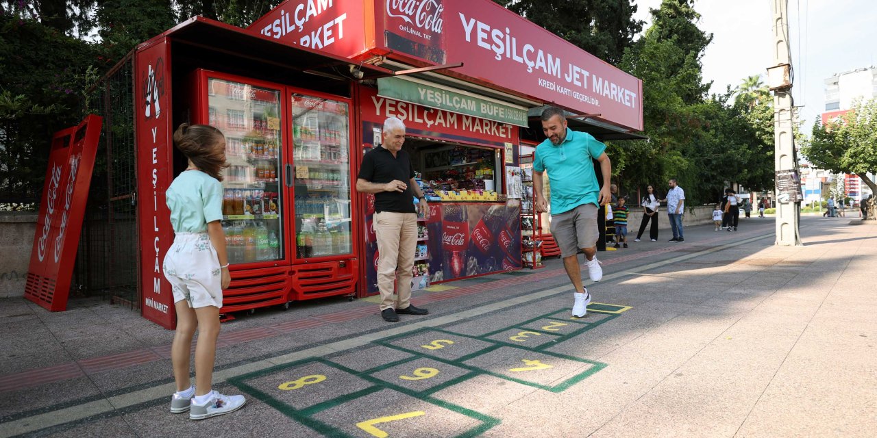 Müşterilerinin mutsuz olduğunu görünce dükkanının önüne seksek çizdi