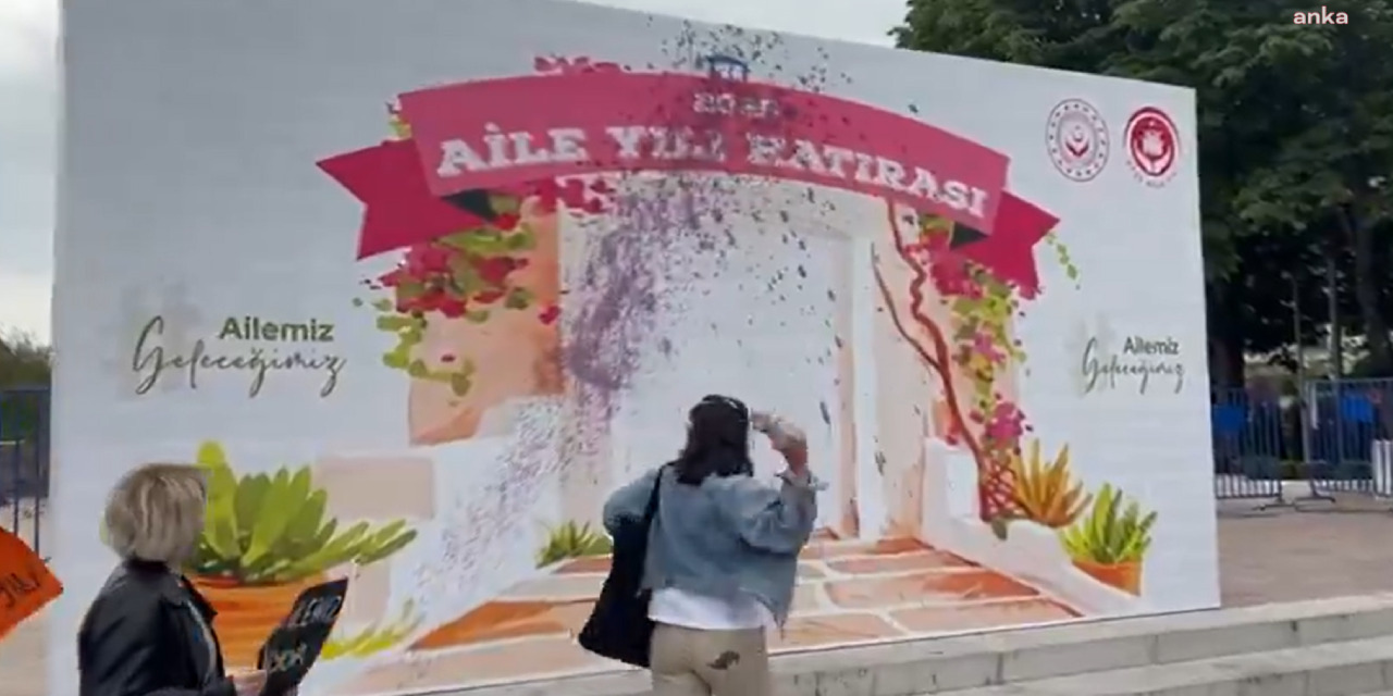 Kadınlar AKP'nin 'Aile Yılı' panosuna mor boya fırlattı