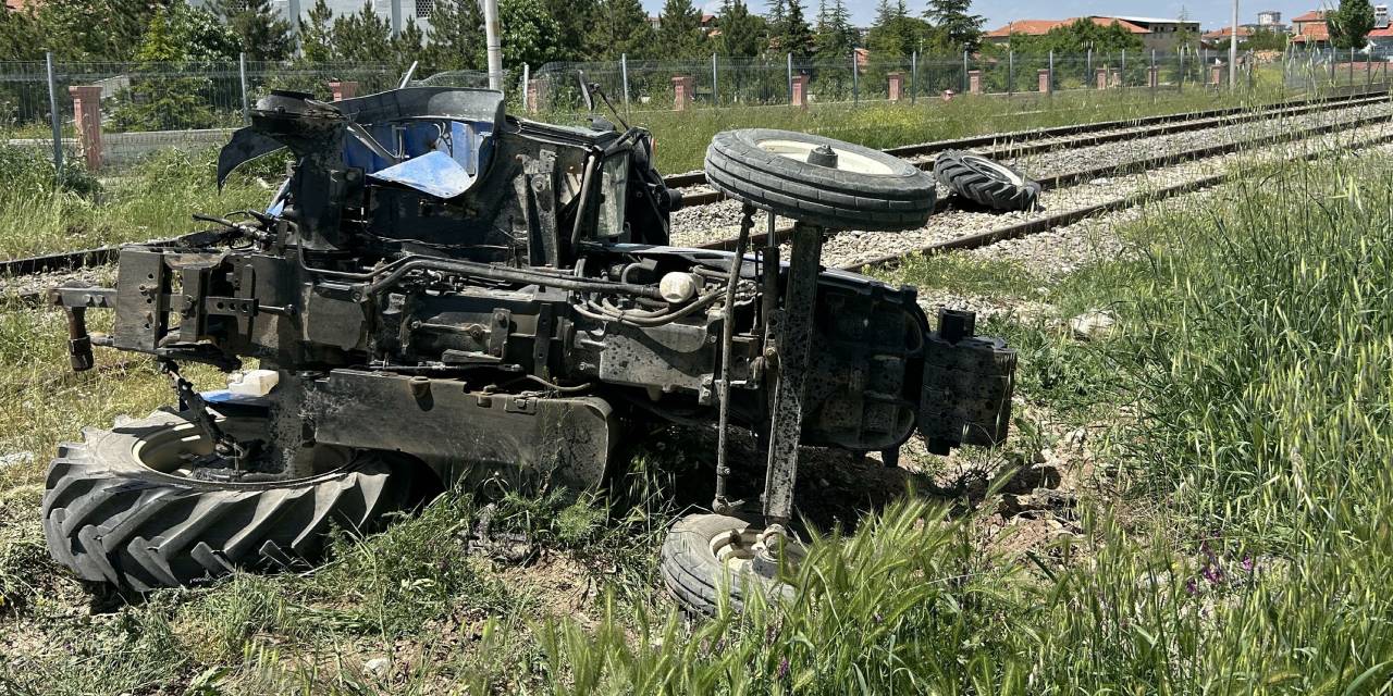 Trenin çarptığı traktör raylara devrildi