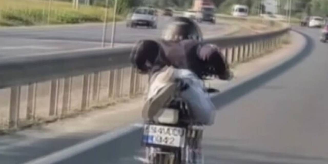 Uzanarak motosiklet sürdü: Ehliyetinden oldu