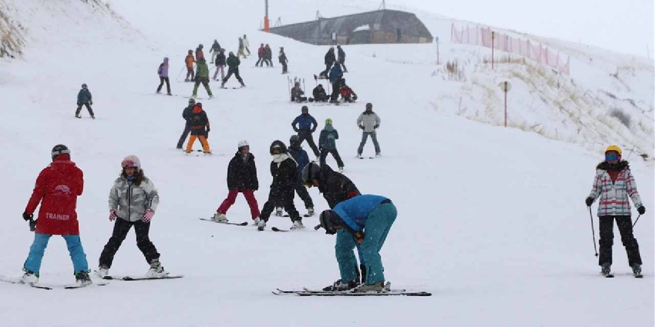 3125 metre rakımlı dağda kar yağışı altında kayak yapıyorlar
