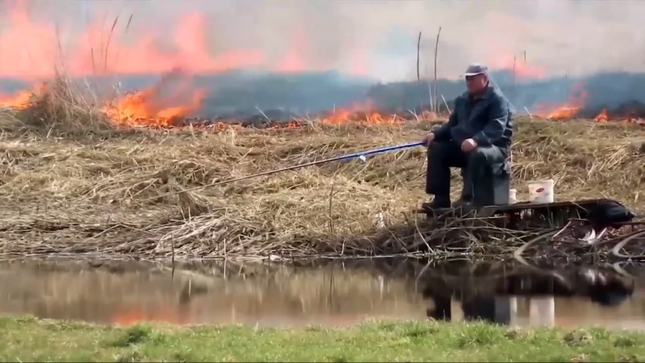 Yangına aldırış etmeden balık tutmaya devam etti