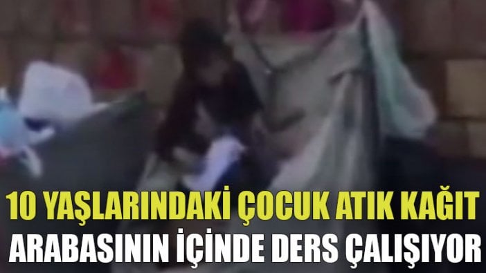 10 yaşlarındaki çocuk atık kağıt arabasının içinde ders çalışıyor