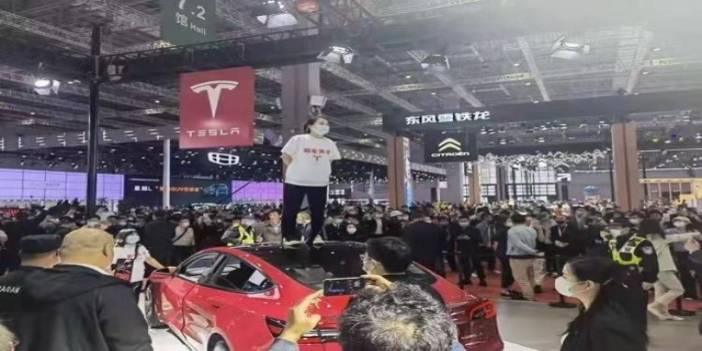 Çinli kadından Tesla protestosu: Fuarda aracın üzerine çıkıp bağırdı